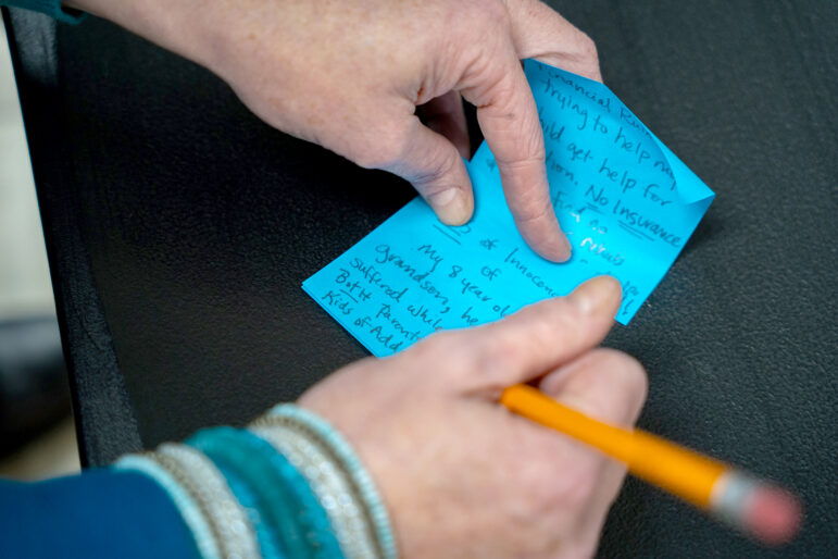 A person with lived experience of addiction writes down their thoughts on how opioid settlement funds should be spent in Mississippi during a listening session hosted by the Gulf States Newsroom at James Moore’s bike shop in Hattiesburg, Mississippi, on January 28, 2026.