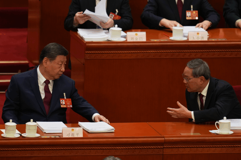 Chinese President Xi Jinping, left and Chinese Premier Li Qiang chat during the opening session of the National People's Congress (NPC) in Beijing, Thursday, March 5, 2026.