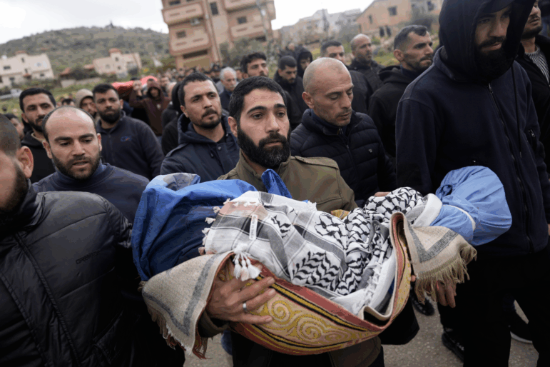 A Palestinian man carries Muhammad Bani Odeh, 5, at the funeral of four members of the Odeh family who were killed in their car by Israeli security forces during an army operation in Tammun, West Bank, Sunday, March 15, 2026.