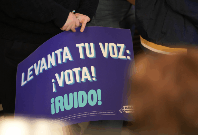 A person holds a blue sign saying in Spanish "Raise your voice: Vote" at a creator event for BOLD Democrats, a Hispanic PAC, in Houston on February 17.